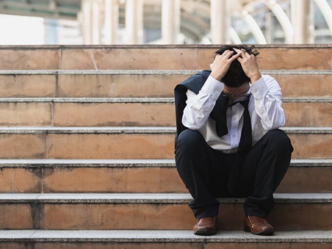 Three Rules to Follow for a Healthy Mind 3 Upset stressed young Asian business man in suit with hands on head sitting on stairs